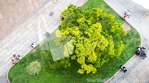 Image of some people from above sitting at a small city park green