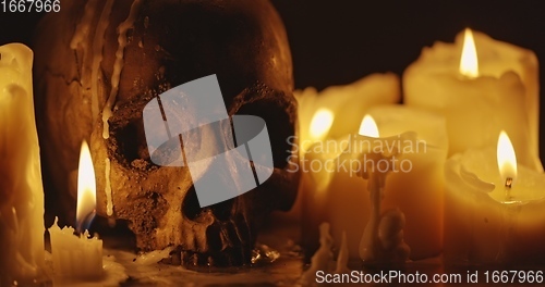 Image of Candles and human skull in darkness closeup footage