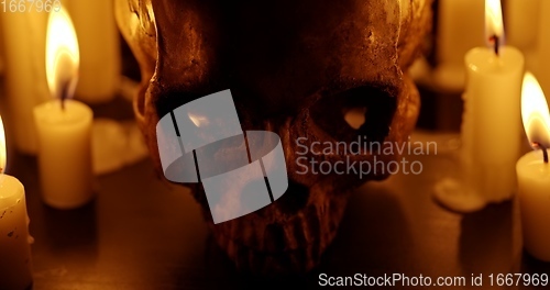 Image of Candles and human skull in darkness closeup footage