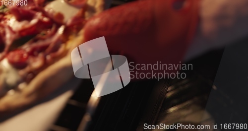 Image of Homemade pizza being checked on in oven