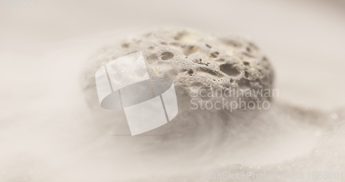 Image of Smoke whirling around small meteorite stone