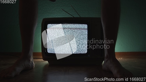 Image of Man sitting on old television