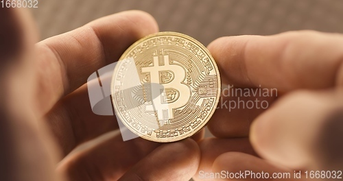 Image of Inspecting Physical bitcoin held in hands closeup