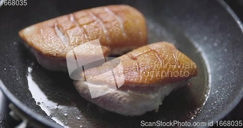 Image of Roast duck breast in frying pen closeup footage