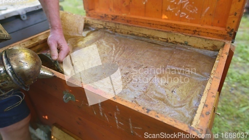 Image of Opening up a beehive with smoke