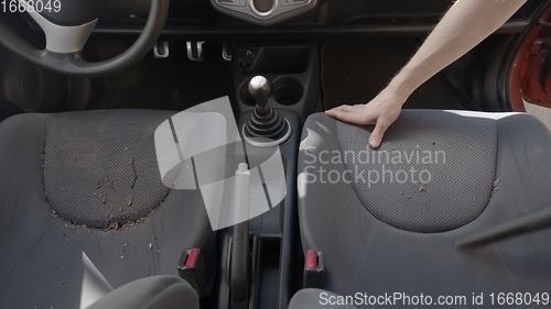 Image of Man cleaning dirty car interior with vacuum cleaner