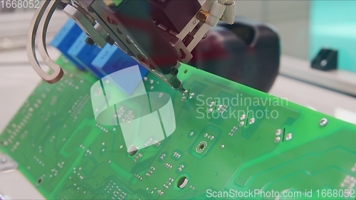 Image of Automated robotic equipment repairing motherboard