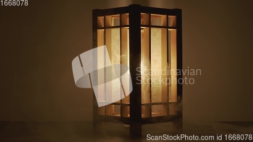 Image of Lamp made out of wood against dark background with smoke