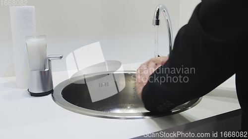 Image of Washing hands in white sink