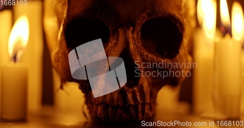 Image of Candles and human skull in darkness closeup footage