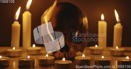 Image of Candles and human skull in darkness closeup footage