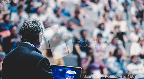 Image of Public speaker giving talk at Business Event.