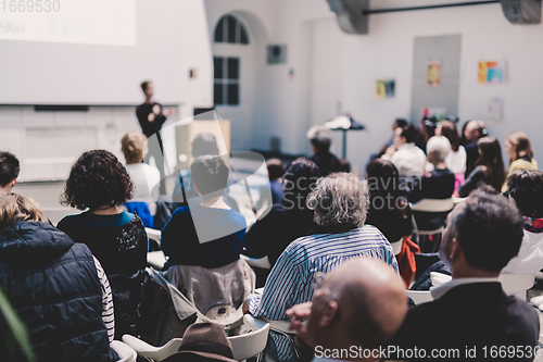 Image of Woman giving presentation in lecture hall at university.