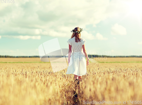 Image of happy young woman in flower wreath on cereal field