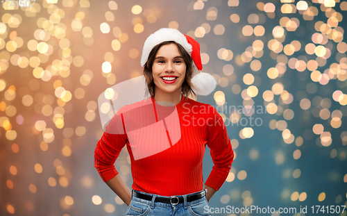 Image of happy young woman in santa hat on christmas