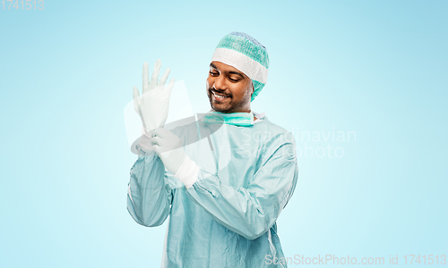 Image of indian male doctor or surgeon putting glove on