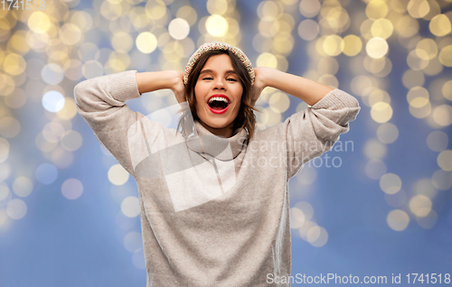 Image of young woman in winter hat and sweater on christmas