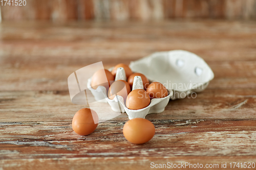 Image of close up of eggs in cardboard box on wooden table