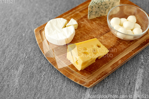 Image of different kinds of cheese on wooden cutting board