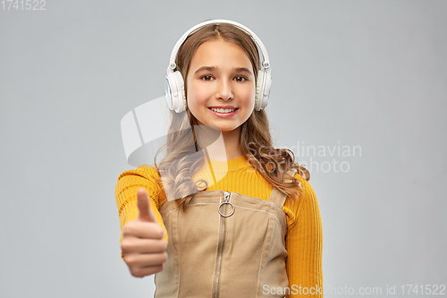 Image of teenage girl in headphones showing thumbs up