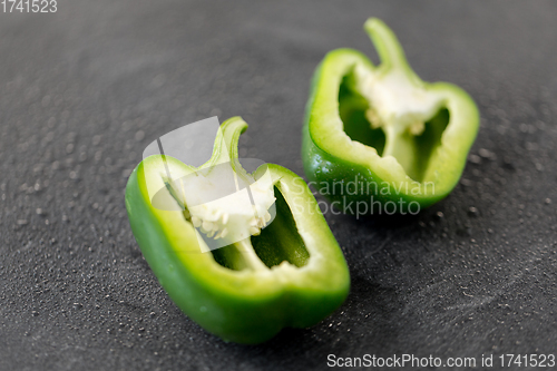 Image of cut green pepper on slate stone background