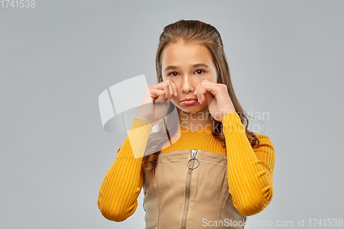Image of unhappy crying teenage girl over gray background