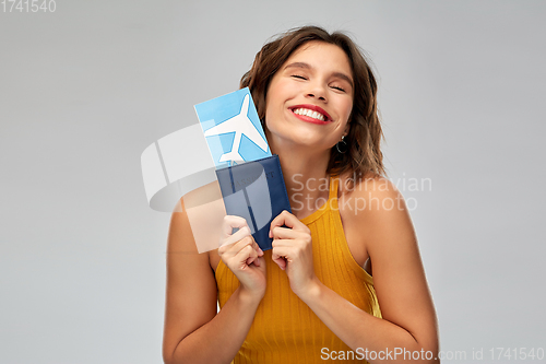 Image of happy young woman with air ticket and passport