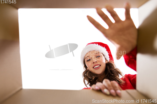 Image of happy young woman looking into open christmas gift