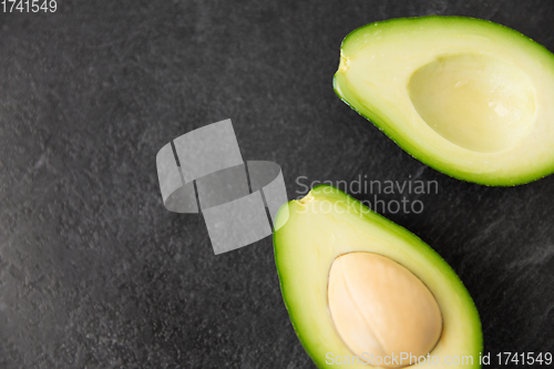 Image of close up of ripe avocado on slate stone background