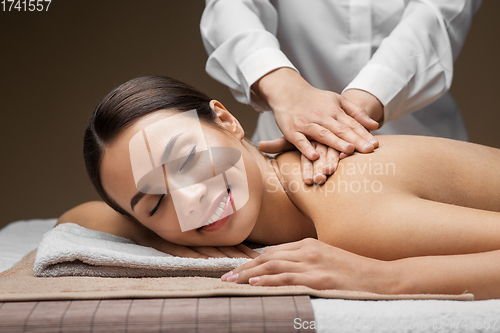 Image of woman lying and having back massage at spa