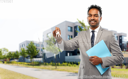 Image of indian man realtor with key and folder in city