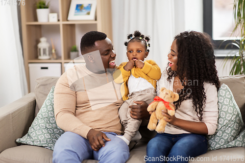 Image of happy african family with baby daughter at home