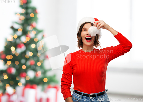 Image of happy young woman in santa hat on christmas