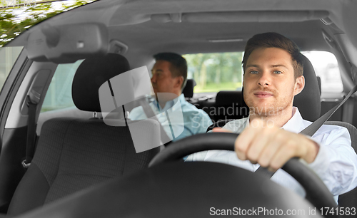 Image of male taxi driver driving car with passenger