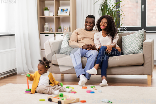 Image of african family with baby daughter playing at home