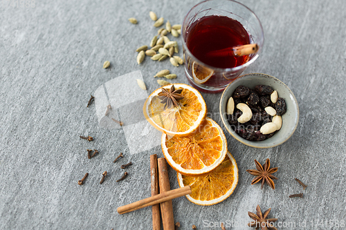 Image of hot mulled wine, orange slices, raisins and spices