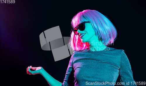 Image of happy woman in pink wig and sunglasses dancing