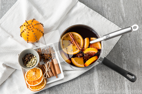 Image of pot with hot mulled wine, orange slices and spices