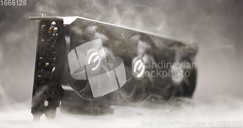 Image of Graphics card with smoke rising and dark background