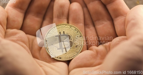 Image of Inspecting Physical bitcoin held in hands closeup