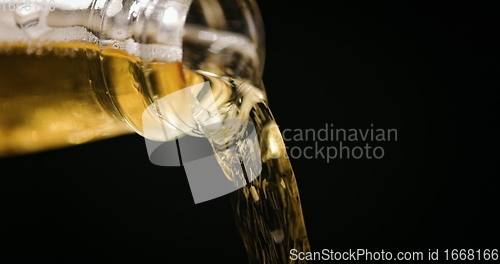 Image of Beer being poured against dark background with slow movements