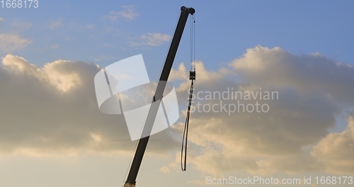 Image of Industrial construction crane against golden sky