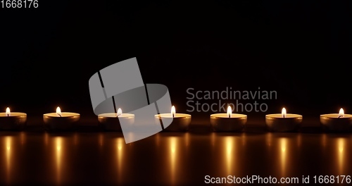 Image of Candles glowing against dark background