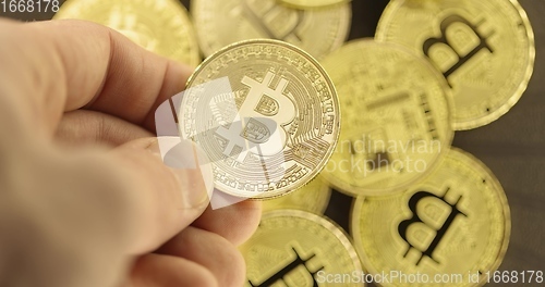 Image of Inspecting Physical bitcoin held in hands closeup