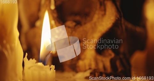 Image of Candles and human skull in darkness closeup footage