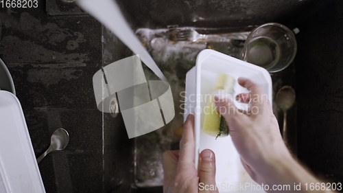 Image of Washing dirty dishware in black sink