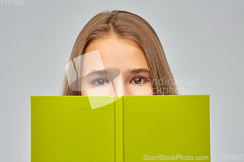 Image of teenage student girl hiding over book