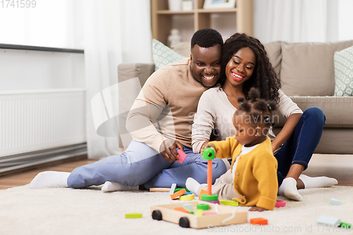 Image of african family playing with baby daughter at home