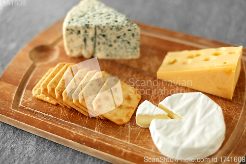 Image of different cheeses and crackers on wooden board