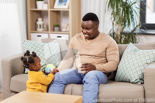 Image of happy african american father with baby at home